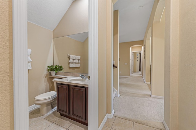 bathroom featuring vanity, toilet, tile patterned floors, and a textured ceiling