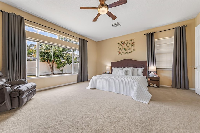bedroom with baseboards, carpet, a ceiling fan, and visible vents