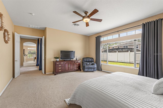 bedroom featuring visible vents, carpet flooring, baseboards, and arched walkways