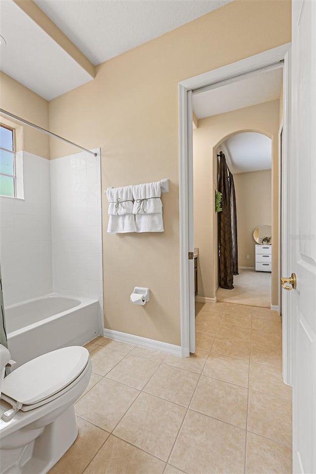 bathroom featuring tile patterned floors, baseboards, toilet, and  shower combination