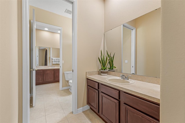 bathroom featuring vanity, tile patterned flooring, baseboards, and toilet