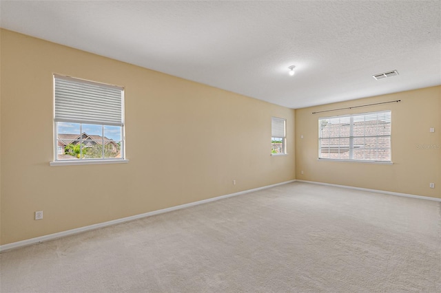 empty room featuring a healthy amount of sunlight, baseboards, and visible vents