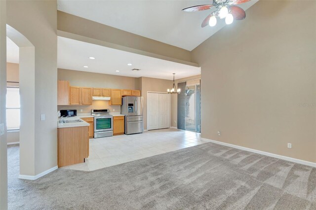 kitchen with stainless steel appliances, light colored carpet, under cabinet range hood, a chandelier, and light countertops