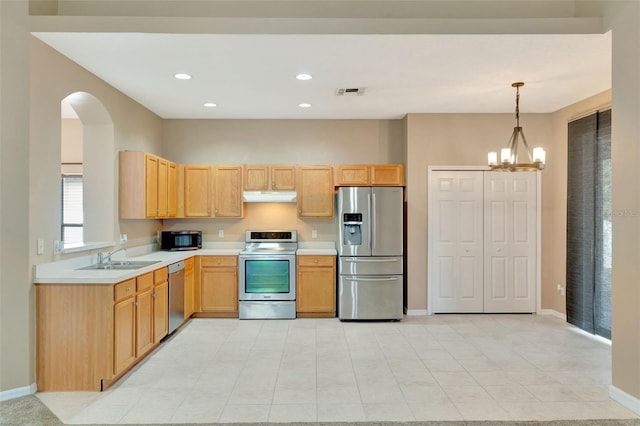 kitchen with appliances with stainless steel finishes, baseboards, a sink, light brown cabinets, and recessed lighting