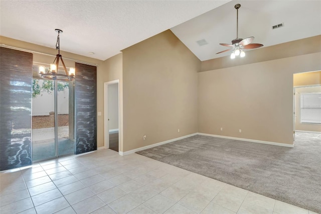 empty room with light carpet, a chandelier, a ceiling fan, lofted ceiling, and light tile patterned flooring