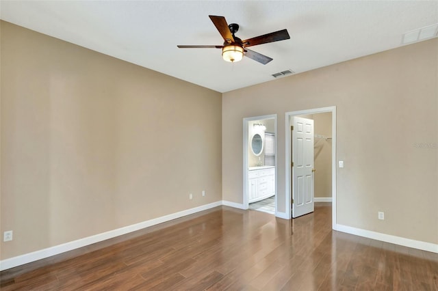 empty room featuring a ceiling fan, wood finished floors, and baseboards