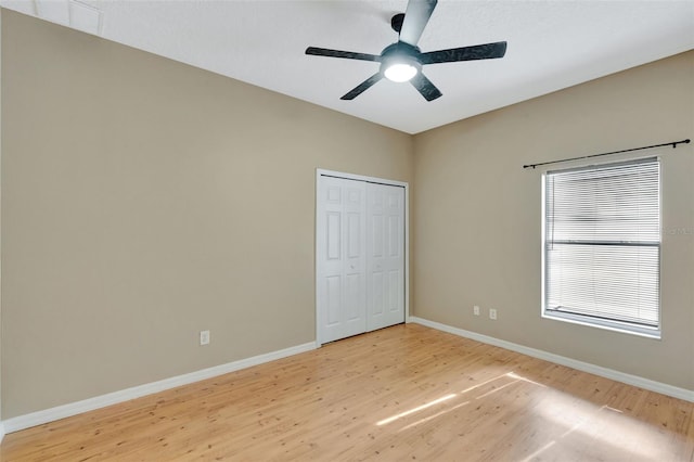 unfurnished bedroom with light wood-style flooring, baseboards, a closet, and ceiling fan