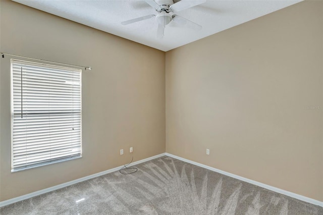 carpeted spare room with baseboards and ceiling fan