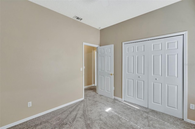 unfurnished bedroom featuring carpet floors, baseboards, and a closet