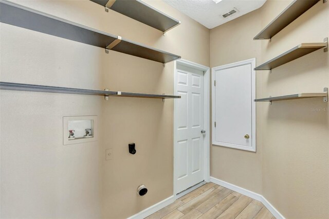 laundry area with hookup for a washing machine, electric dryer hookup, baseboards, and light wood-style flooring