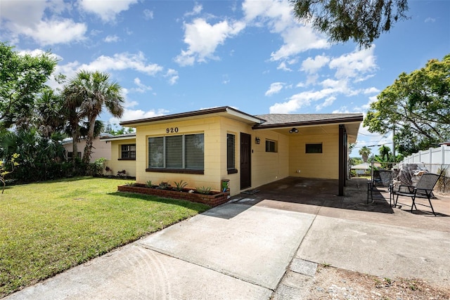 view of front of home featuring fence, an attached carport, driveway, and a front yard