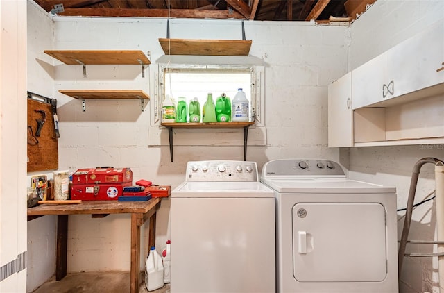 laundry room featuring washing machine and clothes dryer and concrete block wall