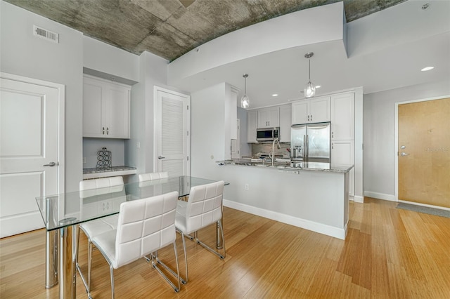 155 S Court Ave Unit 1305, Orlando, FL 32801 - kitchen with visible vents, light wood-style floors, appliances with stainless steel finishes, and white cabinets