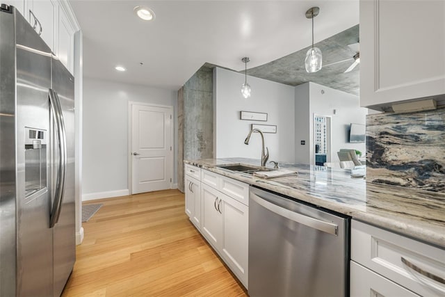 155 S Court Ave Unit 1305, Orlando, FL 32801 - kitchen featuring white cabinets, light stone countertops, a sink, stainless steel appliances, and light wood-type flooring
