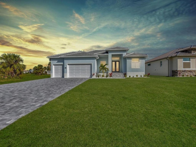 261 Rotonda Blvd S, Rotonda West, FL 33947 - prairie-style house featuring a garage, stucco siding, decorative driveway, and a front yard