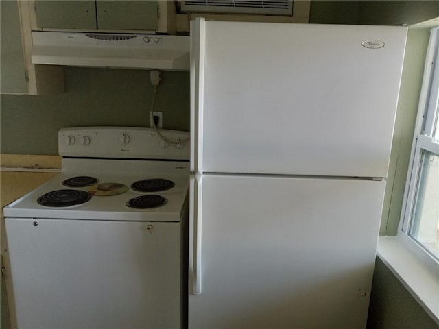 kitchen featuring under cabinet range hood and white appliances