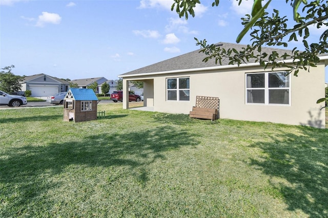rear view of property with stucco siding and a yard