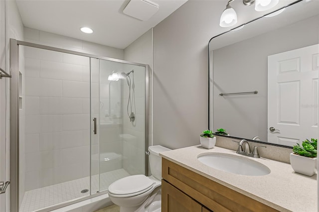 bathroom with toilet, a shower stall, vanity, and recessed lighting