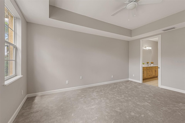 empty room featuring light colored carpet, plenty of natural light, and a ceiling fan