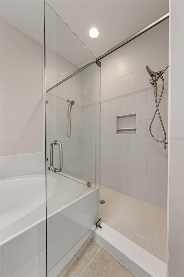 bathroom featuring a stall shower, a garden tub, and recessed lighting