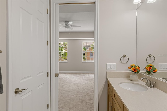 bathroom with ceiling fan, vanity, and baseboards
