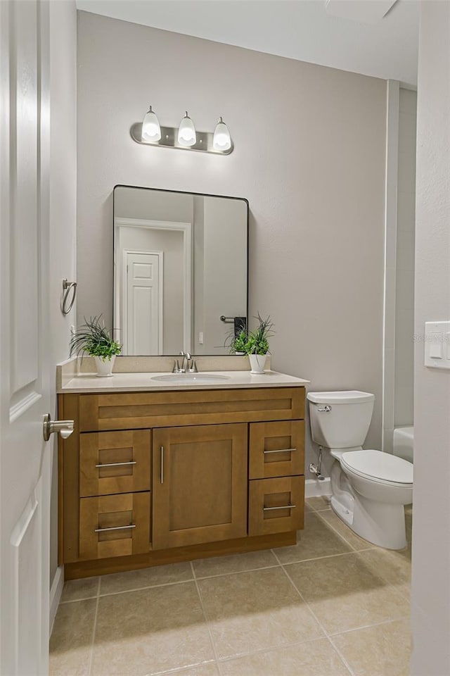bathroom with tile patterned flooring, vanity, and toilet