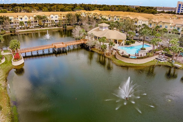 aerial perspective of suburban area featuring a nearby body of water, a notable bridge, and a pool