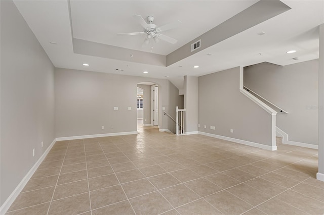 unfurnished living room with ceiling fan, recessed lighting, arched walkways, light tile patterned floors, and baseboards