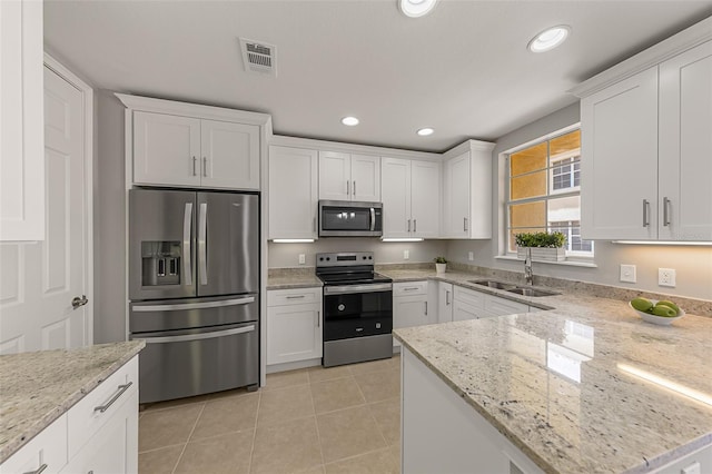 kitchen featuring appliances with stainless steel finishes, a sink, white cabinetry, light tile patterned floors, and recessed lighting