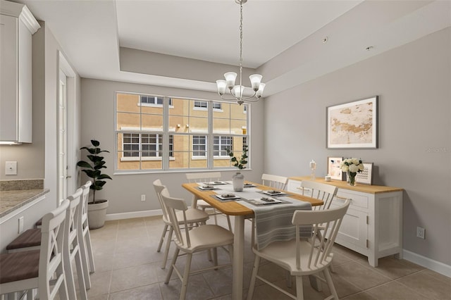 dining area featuring a chandelier, light tile patterned flooring, and baseboards