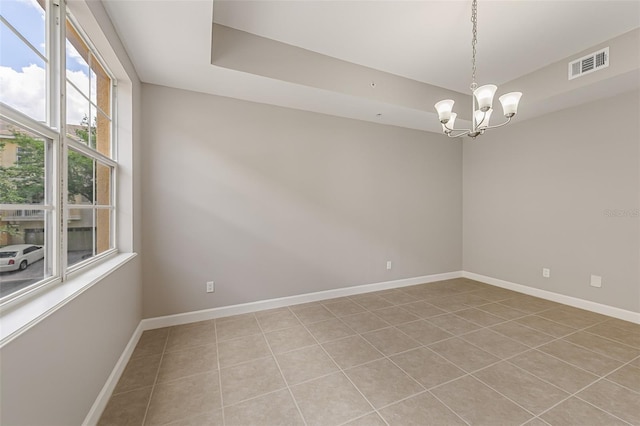 spare room with light tile patterned flooring, a chandelier, and baseboards