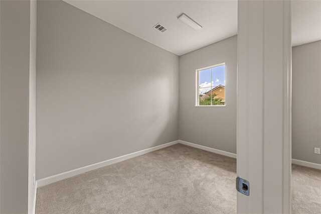empty room with light colored carpet and baseboards