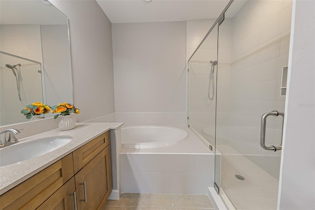bathroom with a shower stall, vanity, a garden tub, and tile patterned floors