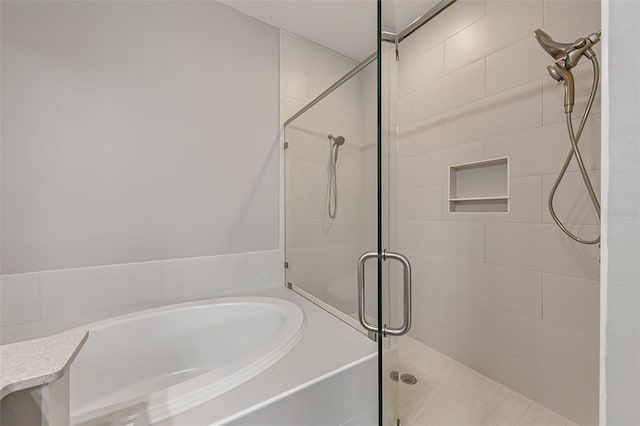 bathroom featuring a stall shower and a garden tub