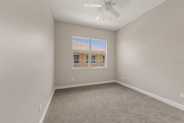 unfurnished room with carpet flooring, baseboards, and a ceiling fan