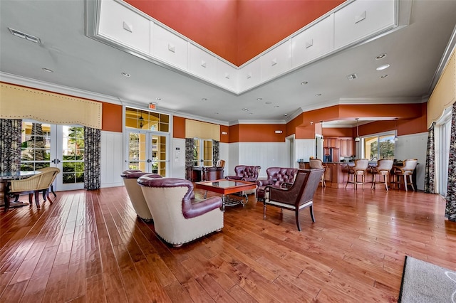 living room with french doors, wood-type flooring, crown molding, and recessed lighting