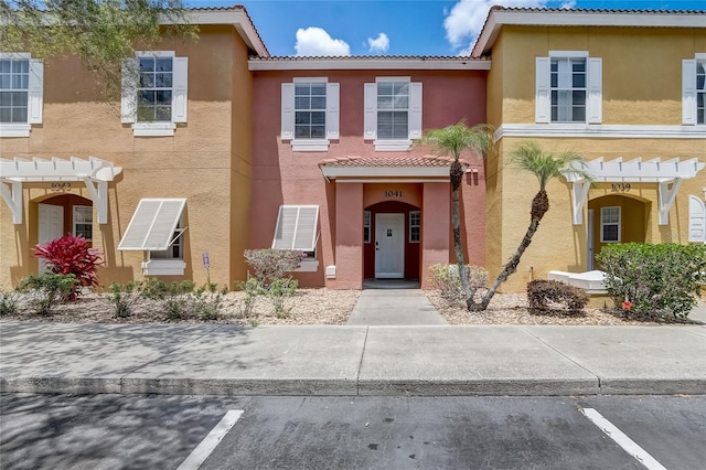 1041 Park Ridge Cir, Kissimmee, FL 34746 - townhome / multi-family property featuring stucco siding, a pergola, and a tile roof