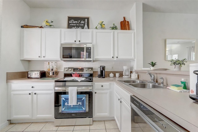 1041 Park Ridge Cir, Kissimmee, FL 34746 - kitchen with appliances with stainless steel finishes, white cabinetry, a sink, light countertops, and light tile patterned flooring