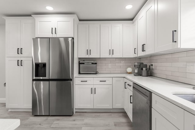 kitchen with light countertops, appliances with stainless steel finishes, and white cabinetry