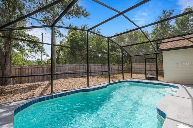 view of pool featuring a fenced backyard and glass enclosure