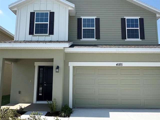view of front of property featuring board and batten siding, driveway, and a garage