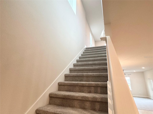 stairs featuring baseboards and carpet flooring