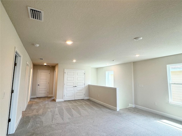 interior space with baseboards, recessed lighting, a textured ceiling, and visible vents