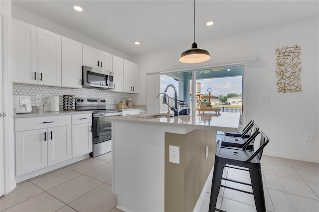 1312 Axel Graeson Ave, Kissimmee, FL 34744 - kitchen featuring light tile patterned flooring, appliances with stainless steel finishes, a sink, light countertops, and decorative backsplash