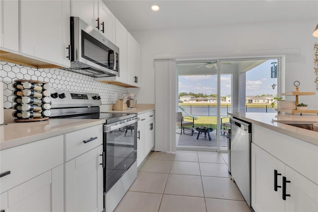 1312 Axel Graeson Ave, Kissimmee, FL 34744 - kitchen with backsplash, stainless steel appliances, white cabinetry, and light countertops