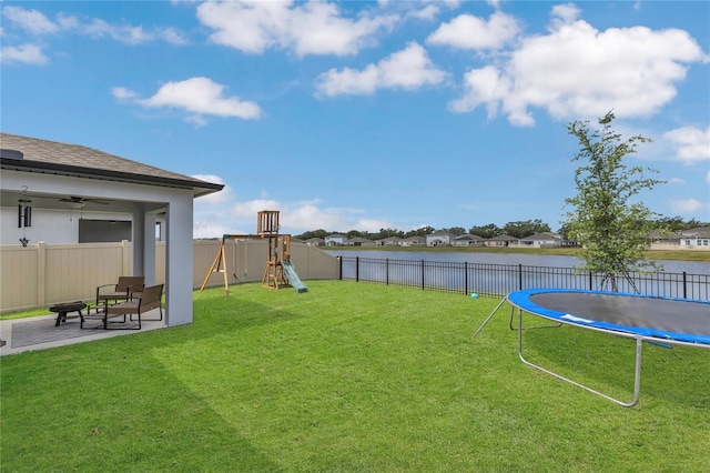 1312 Axel Graeson Ave, Kissimmee, FL 34744 - view of yard featuring a trampoline, a fenced backyard, a water view, a playground, and a patio