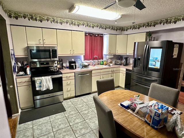 300 Broadview Ave, Altamonte Springs, FL 32701 - kitchen featuring appliances with stainless steel finishes, a sink, light countertops, cream cabinetry, and a textured ceiling