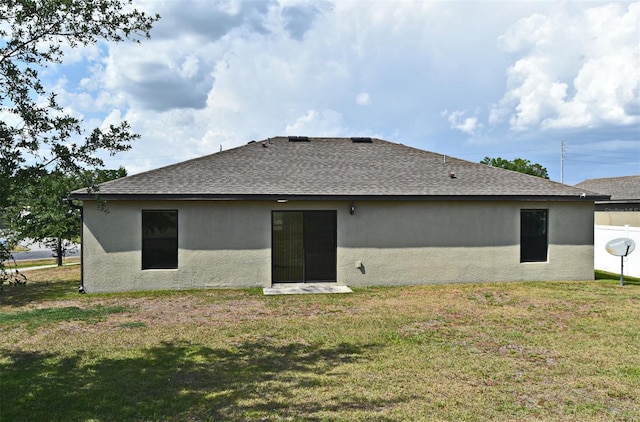 35734 Rose Moss Ave, Leesburg, FL 34788 - rear view of property featuring a lawn, a shingled roof, and stucco siding