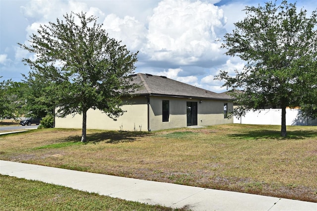 35734 Rose Moss Ave, Leesburg, FL 34788 - view of side of property with stucco siding, roof with shingles, fence, and a yard