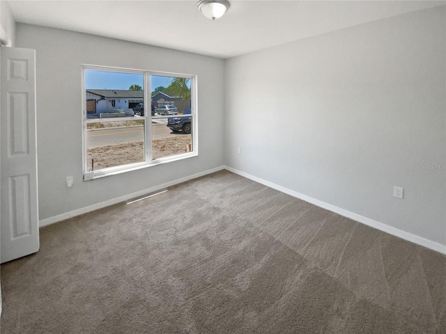carpeted spare room with baseboards